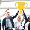 Smiling team members holding up a trophy